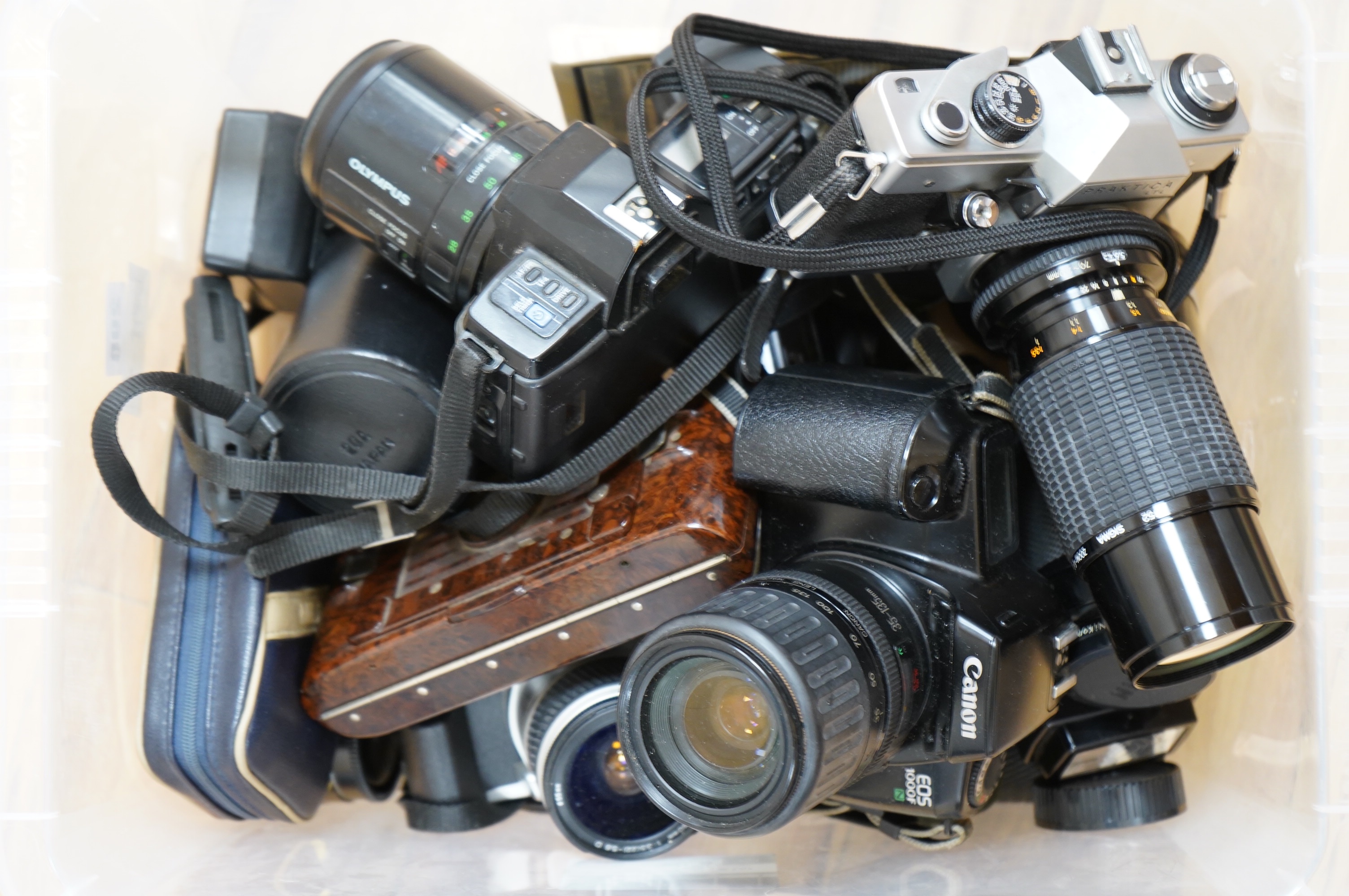 A quantity of cameras and lenses to include a Praktica LTL, Olympus OM77AF, Canon 1000F and Tamron 70-150 lens. Condition - varies